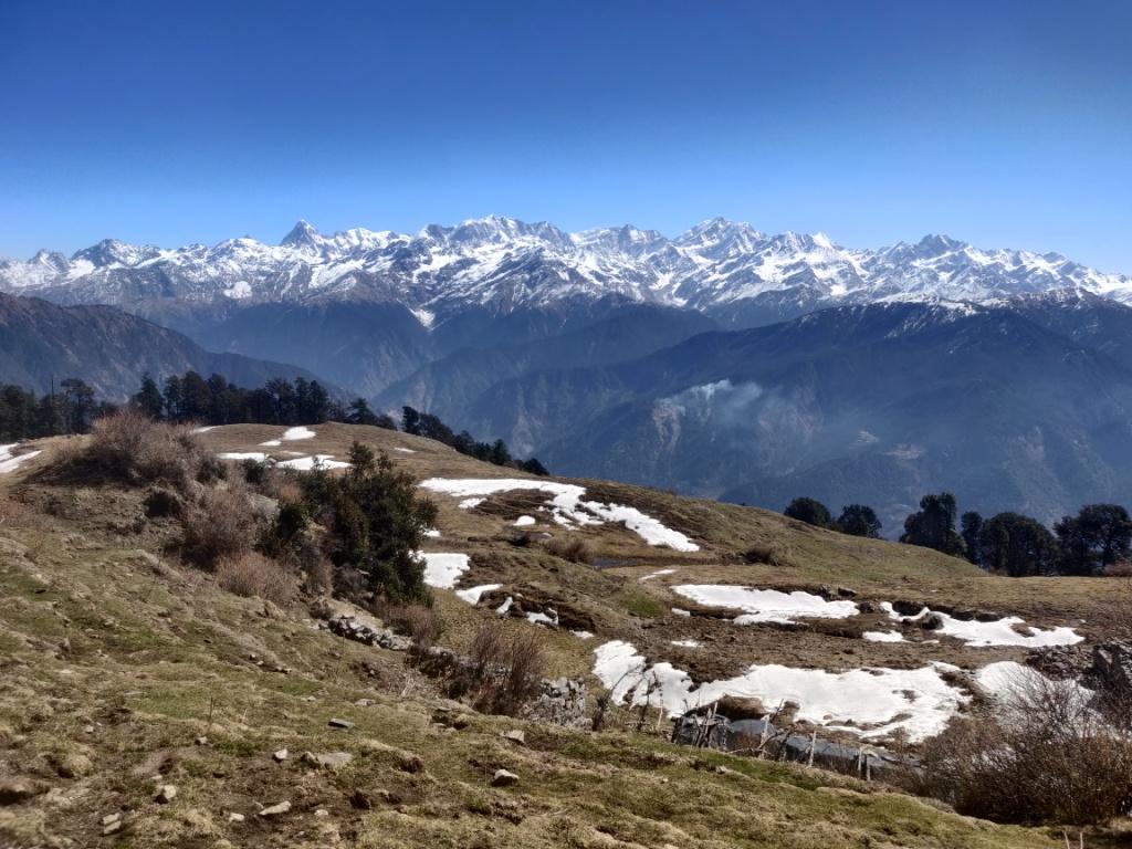 A small team spread out across a high bugyal.